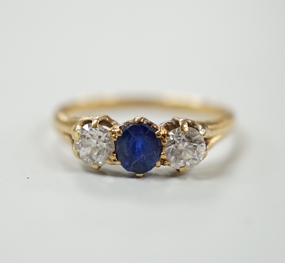 A yellow metal, single stone sapphire and two stone diamond set ring, size L, gross weight 2.3 grams.